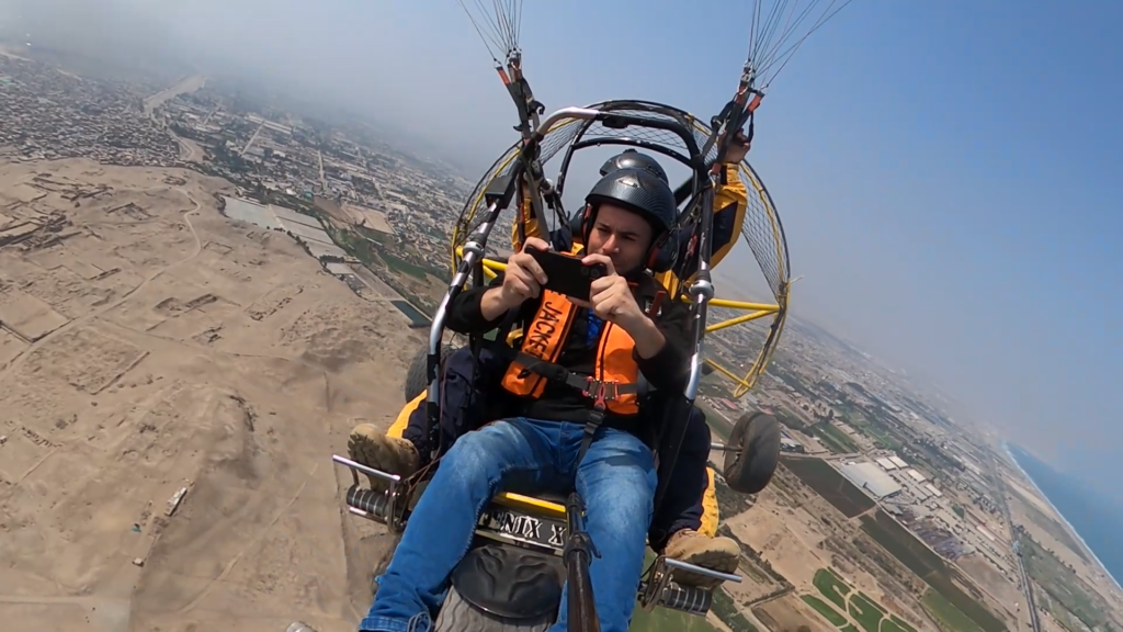 Vista panorámica de Lima desde un vuelo en parapente motorizado, con el océano Pacífico y el valle en el horizonte.