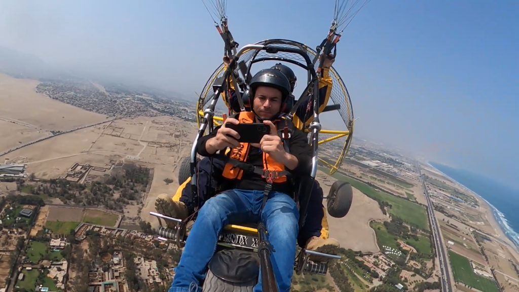 Vista panorámica de Lima desde un vuelo en parapente motorizado, con el océano Pacífico y el valle en el horizonte.